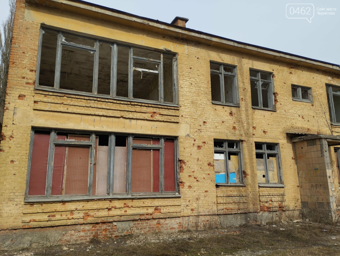 Вікна на першому поверсі будівлі чимось закриті, а ось другий - переважно з віконницями без скла