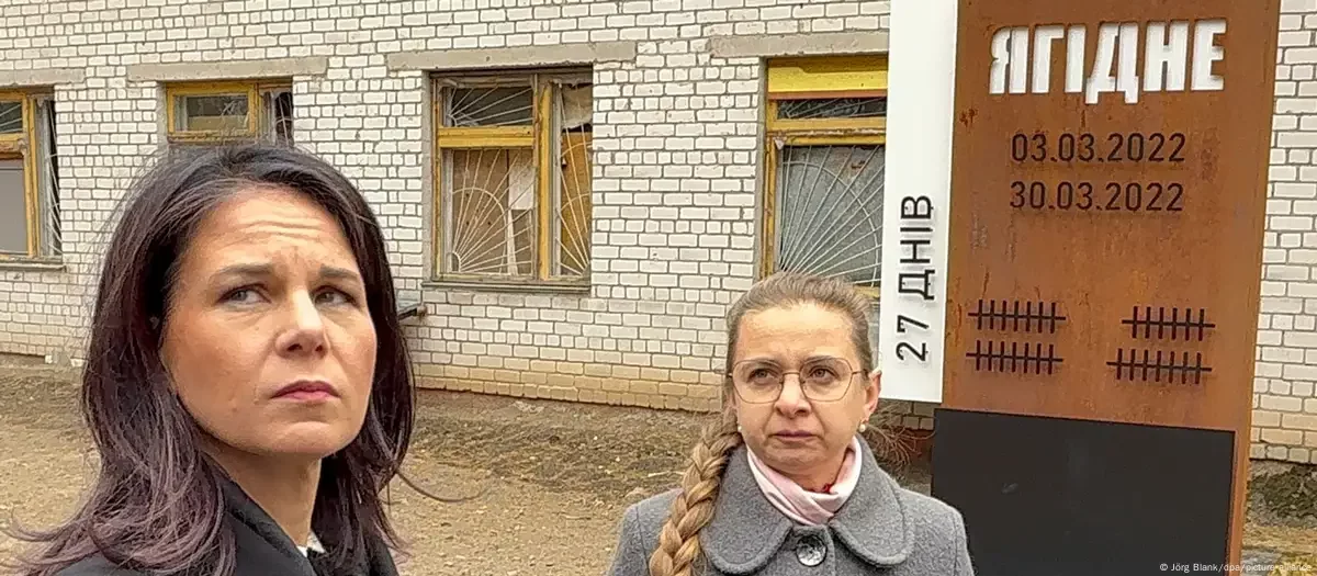 Анналена Бербок (зліва) біля меморіалу в Ягідному